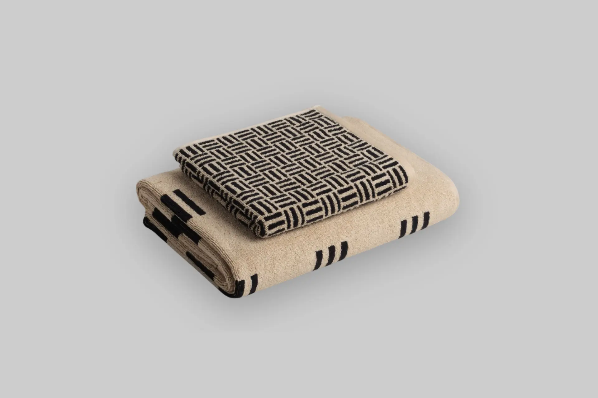 Folded Baina Solitary Set towels in Sand and Noir