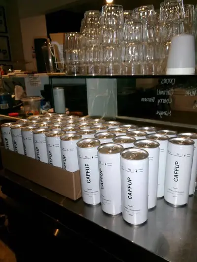 Simple but distinctive CaffUp cans packaged and ready for distribution