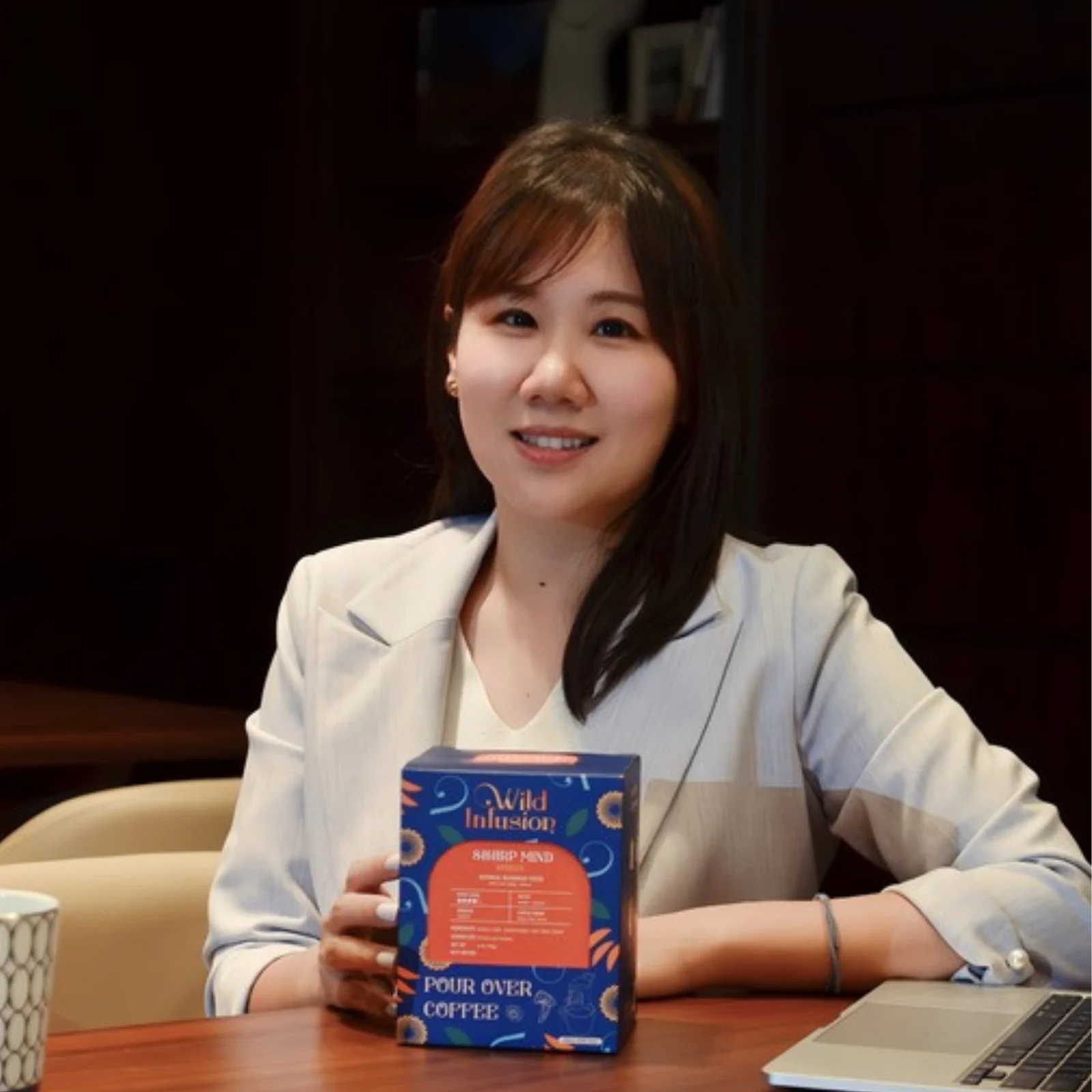 Shelley Tseng, founder of Wild Infusion Coffee, holding a box of Wild Infusion pour-over coffee